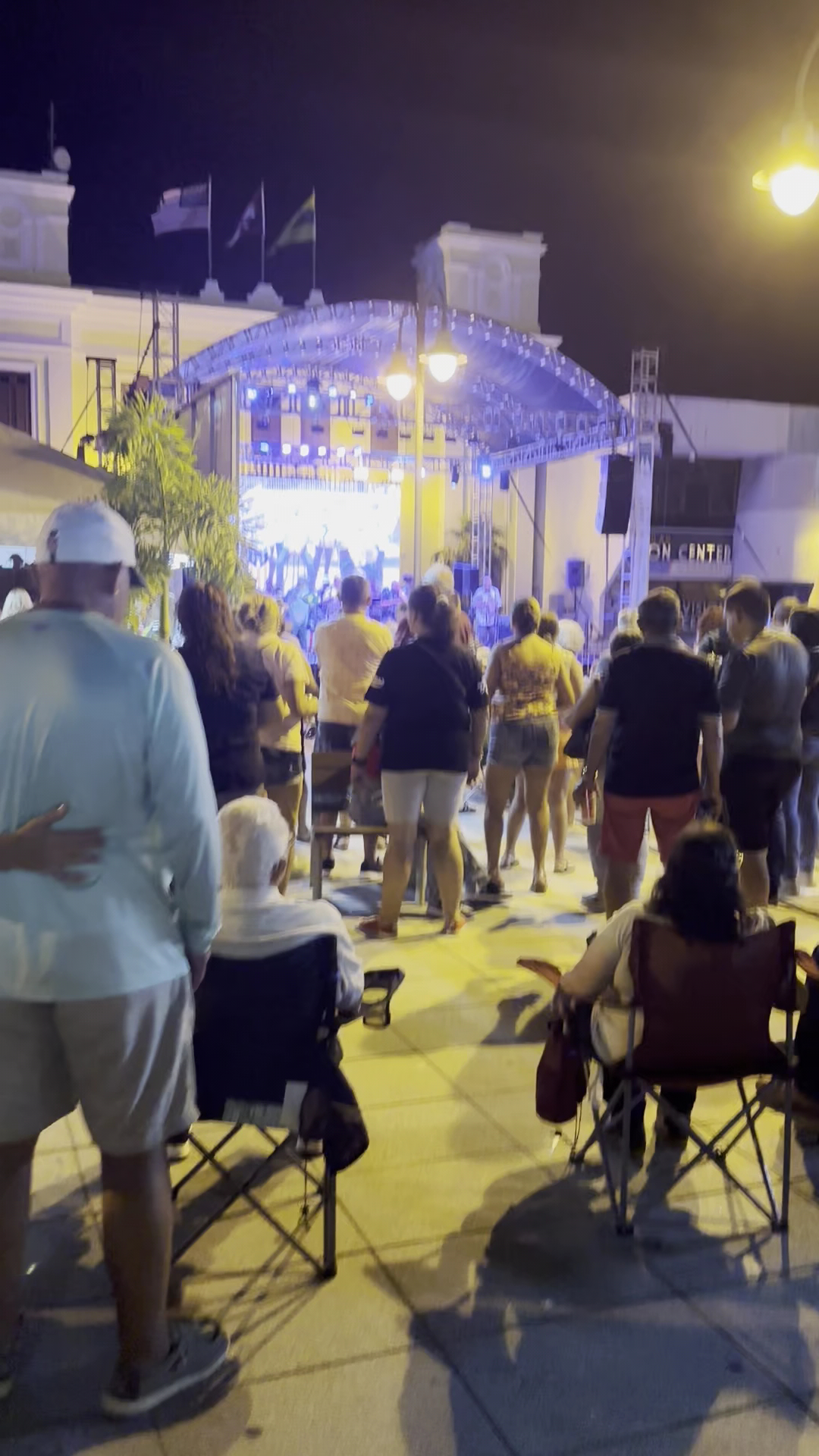 People gather to watch an outdoor performance at night